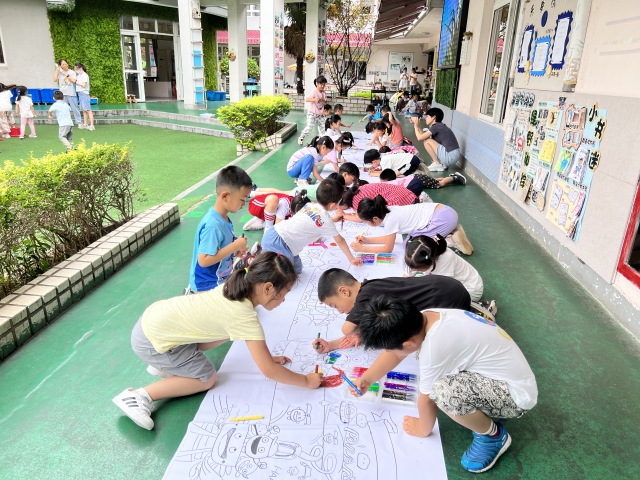 图为孩子们一起画大地画回忆幼儿园生活 幼儿园供图.JPG
